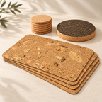 Angled premium product view of four Iceberg Natural textured cork placemats, stack of six pale cork coasters and dark cork trivet.