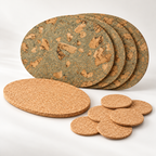 Angled product view of four Oval Iceberg Grey cork placemats, six natural round coasters and one large natural oval cork trivet.