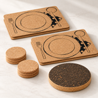 Angled studio view of four Table Service printed placemats, six pale cork coasters and one dark circular cork trivet.