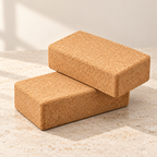 Two 65 mm cork yoga blocks layered on a pale travertine surface, natural Portuguese cork texture