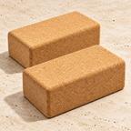 Two matching CorkMart 75 mm natural cork yoga blocks on a pale travertine background