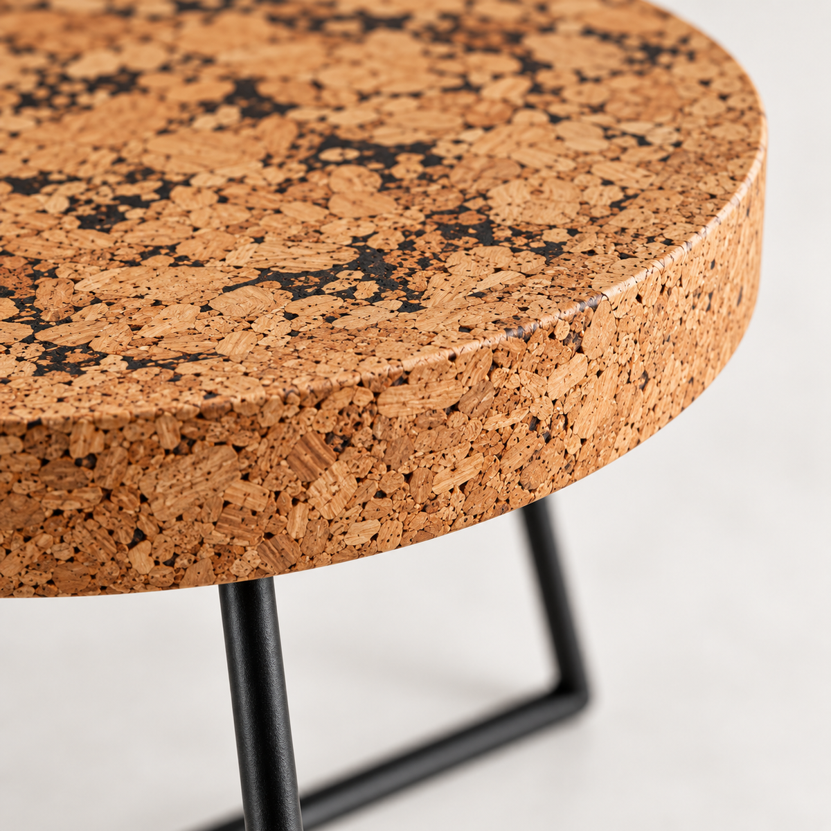 Macro detail of patterned natural cork tabletop edge and black metal frame