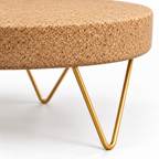 Macro detail of natural cork tabletop edge and gold-tone zig-zag metal leg structure