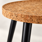 Macro detail of natural cork tabletop edge and dark wooden leg