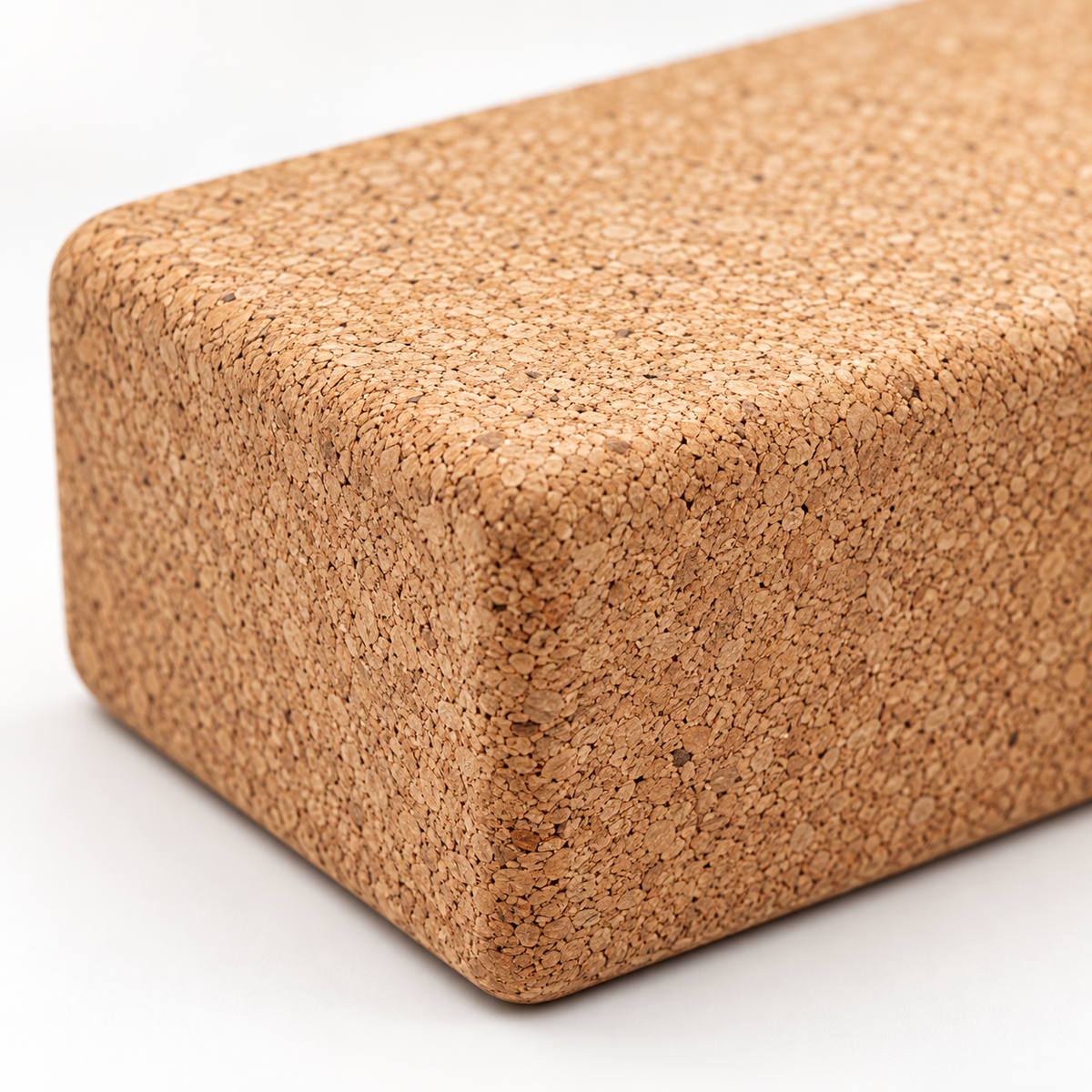 Macro detail of natural cork texture and rounded edge on 75 mm cork yoga block