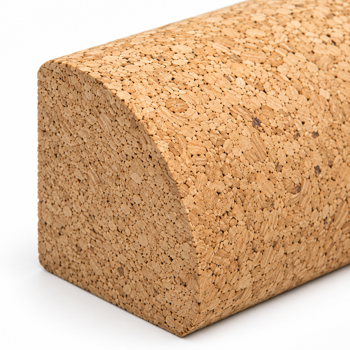 Macro detail of natural cork texture and curved profile on quarter-round yoga block