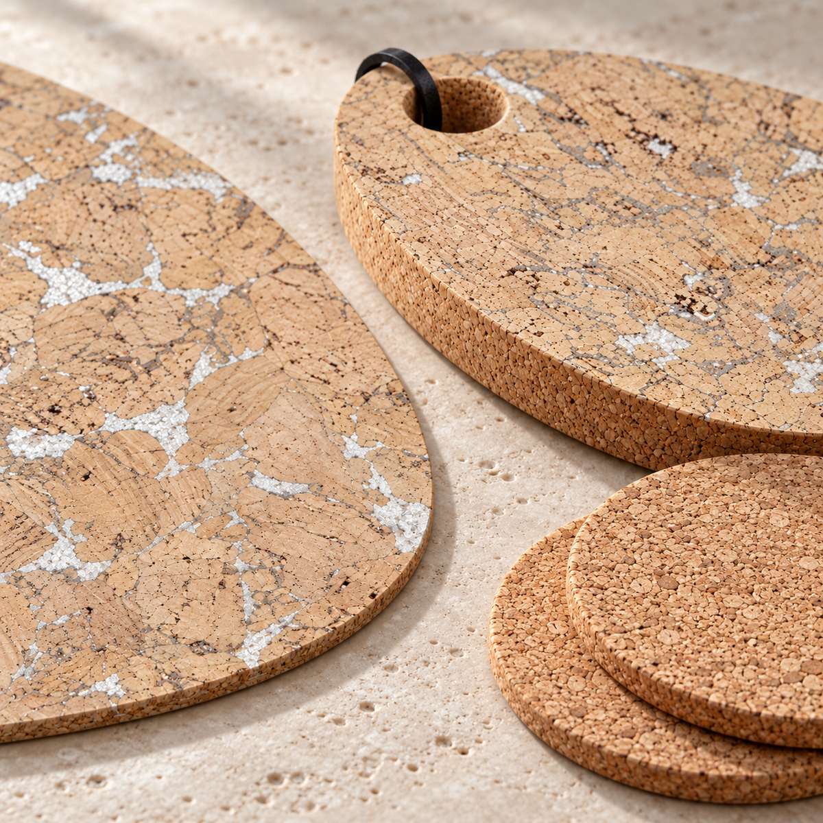 Macro details of silver-flecked Snow White cork placemat and 15 mm tear trivet beside natural round coasters