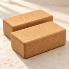 Close-up of two rounded natural cork yoga blocks showing fine-grained cork surface and edges