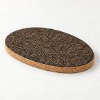 Dark oval cork trivet, 34 × 22 cm, 20 mm — premium studio hero